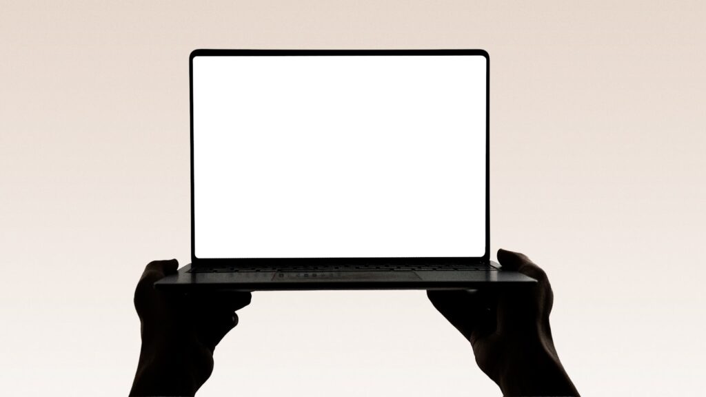 Hands hold up an open laptop with a blank screen – Analyzing the Elementor Pro RCE Vulnerability (CVE-2026-32475)