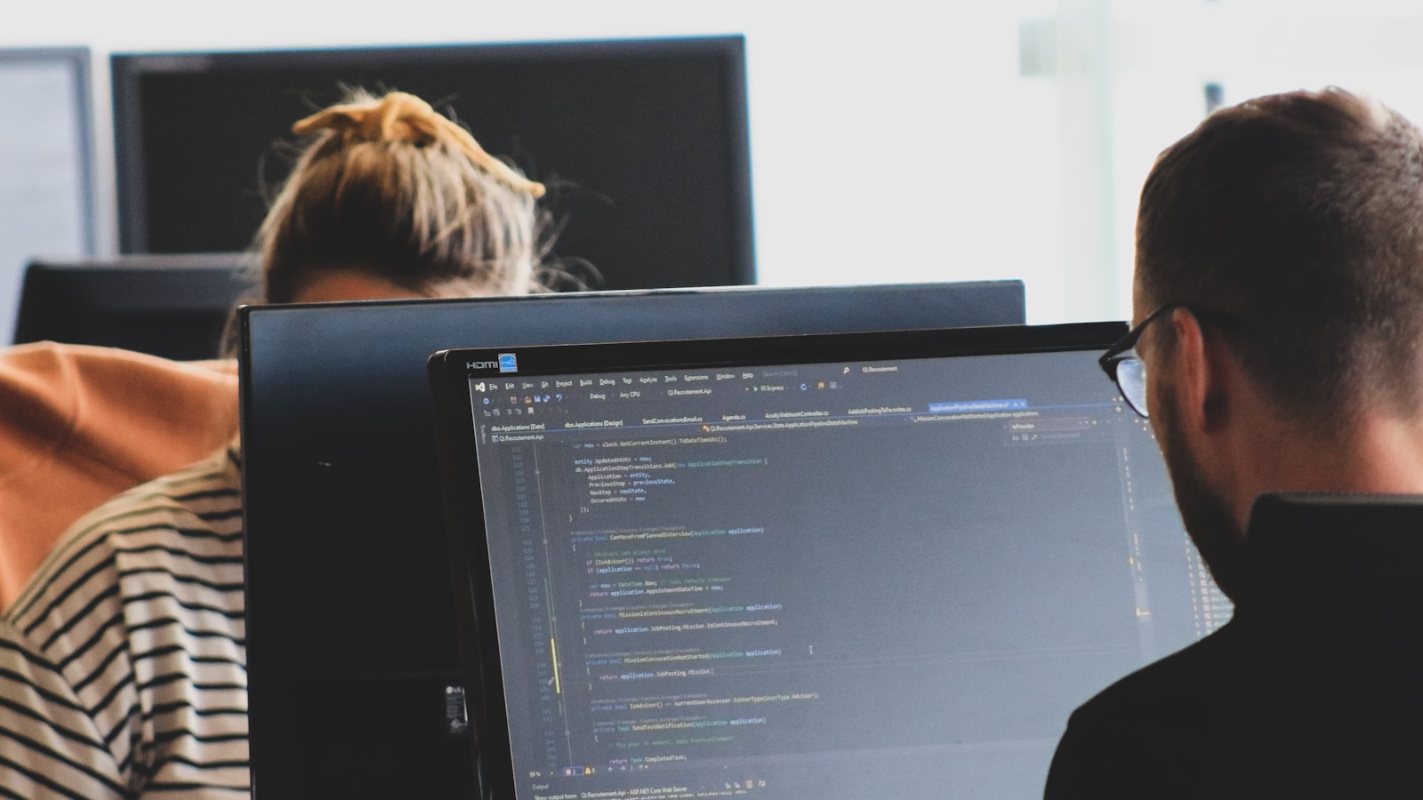 Woman in black shirt sitting beside black flat screen computer monitor – Sucuri Account Authentication Migration: Schedule, Impact, and Transition Det