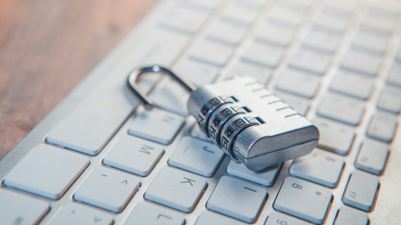 A combination lock rests on a computer keyboard – Securing SaaS Environments with Automatic Remediation Policies